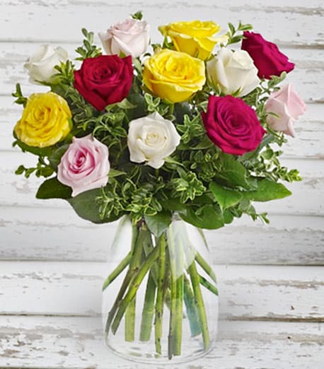 Bouquet of multicolored roses in a clear glass vase