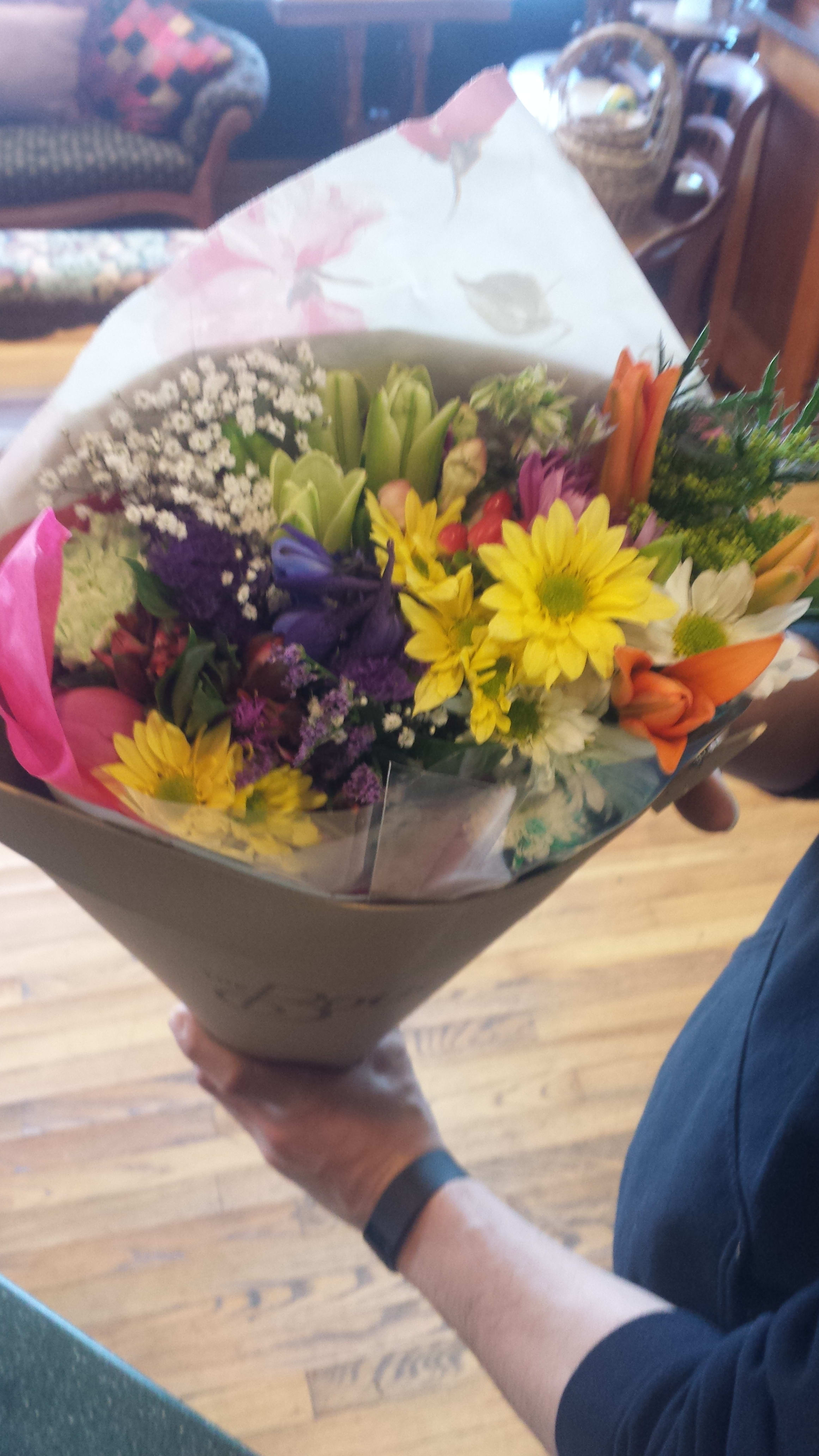 Mixed bouquet of colorful flowers wrapped in paper