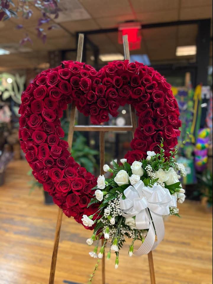 Heart-shaped red rose wreath with a white rose bouquet and ribbon