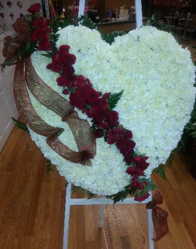 Heart-shaped white floral arrangement with a red rose diagonal and ribbon