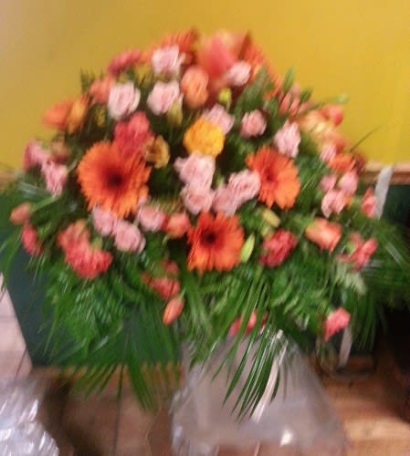 Large bouquet of orange and pink flowers with greenery