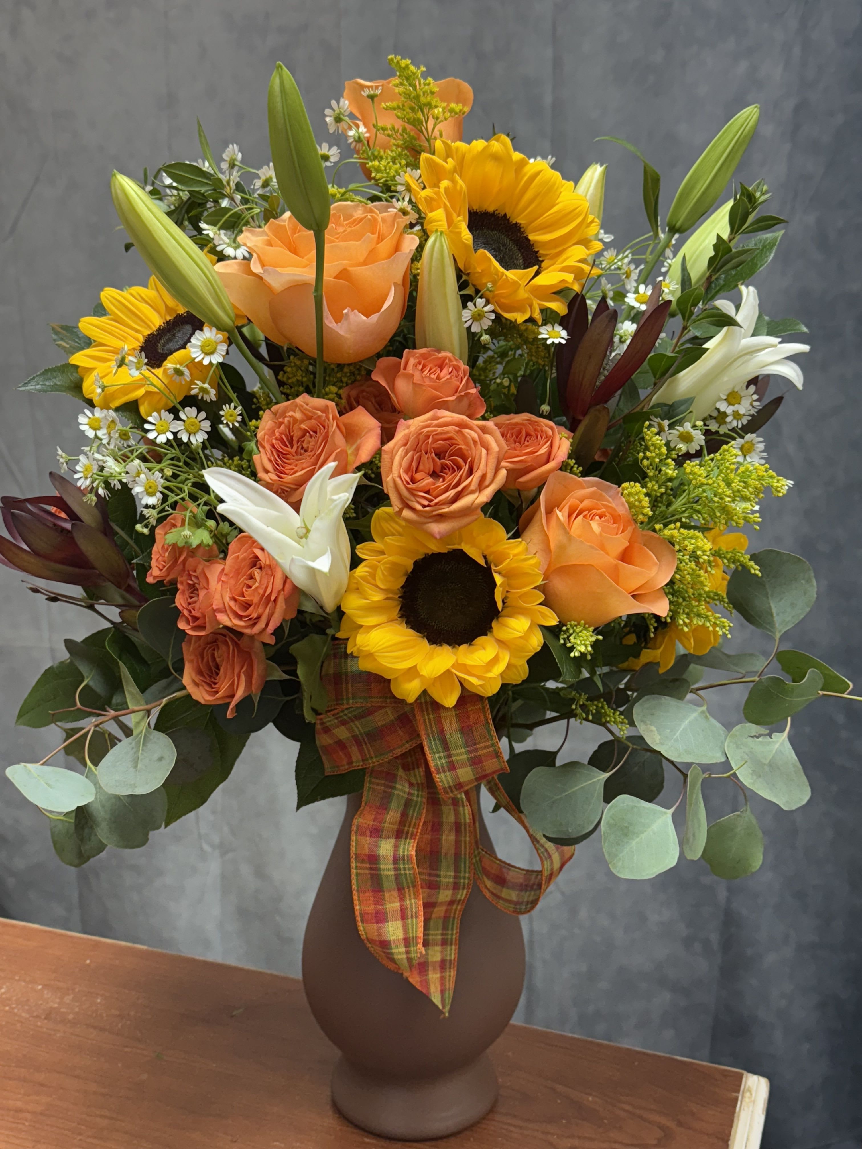 Fall Elegance  -  Celebrate a special birthday with our premium fall vase! This gorgeous arrangement features sunflowers, roses, spray roses, lilies, and more, all beautifully tied together with a festive fall ribbon. Perfect for making the day extra special! Order yours today to bring joy to someone's Day! 