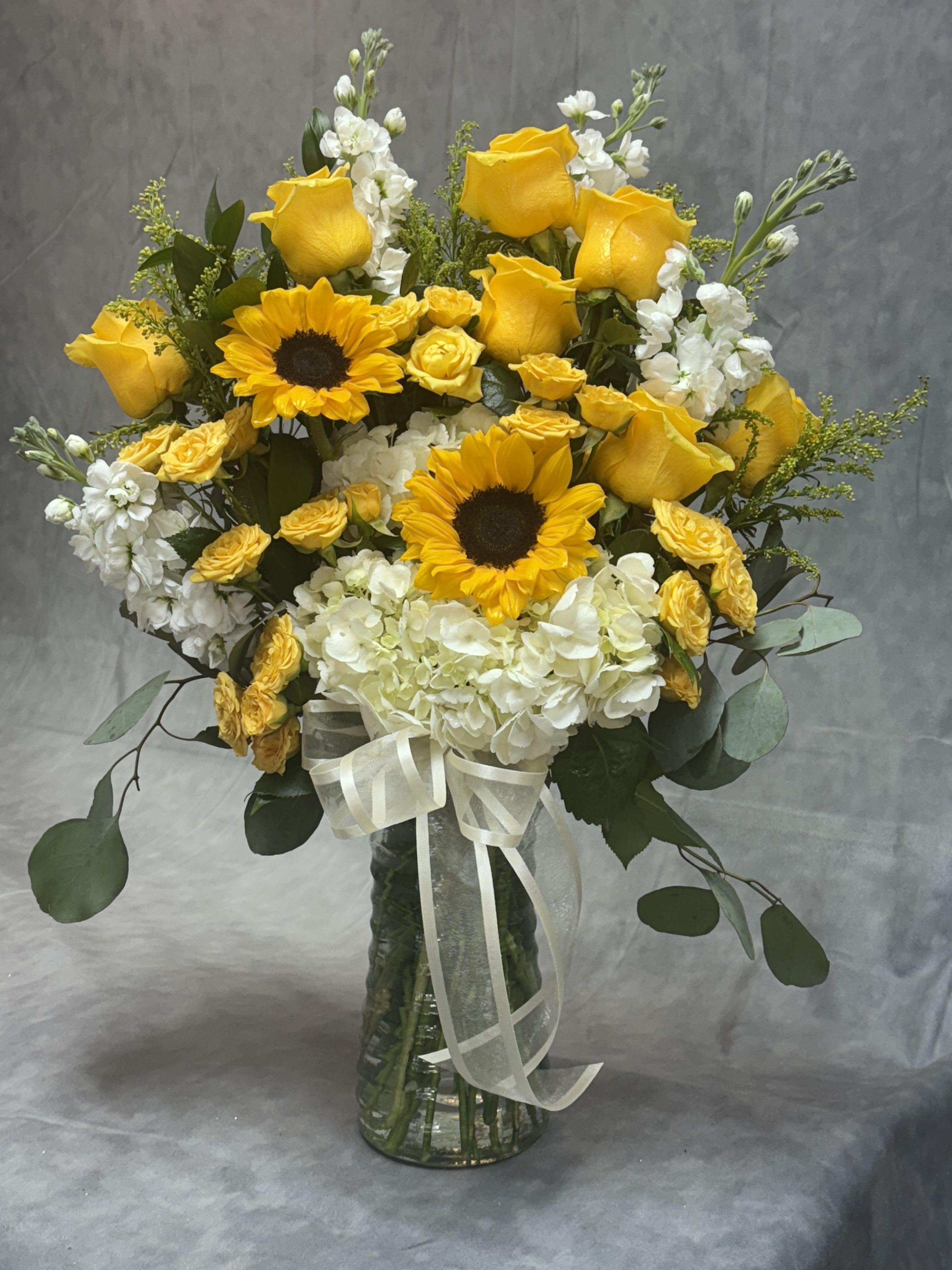Golden Sunshine  - Bright yellow roses and sunflowers with white hydrangeas and greens in a clear vase, tied with ribbon-cheerful, fresh and gift-ready for all occasion 