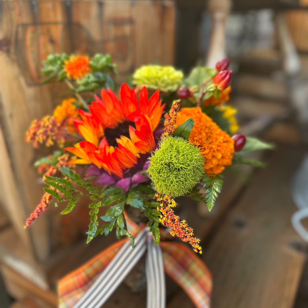 Bright mixed bouquet with orange and yellow blooms in a vase