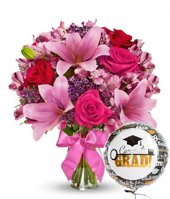 Pink and red bouquet with a graduation balloon and ribbon in a glass vase