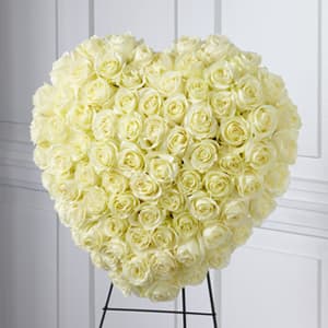 Heart-shaped arrangement of pale yellow roses on a stand
