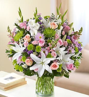 Sincerest Sorrow - Multicolor Pastel - Product ID: 95434   Remember a loved one who has passed on with a stunning tribute arrangement. The elegance of pastel-colored roses, lilies, gladiolas, stock, snapdragons and more offers your heartfelt memories of a beautiful life. Lush, pastel-toned arrangement of roses, lilies, gladiolas, stock, spider mums, poms, snapdragons, mini carnations, daisy poms, monte casino and waxflower, accented with variegated pittosporum, salal and myrtle Hand-designed by our select florists in a classic glass cylinder vase; vase measures 8"H Can be sent to the home of friends, family members or business associates, or to the funeral service Large arrangement measures approximately 24"H x 22"L Medium arrangement measures approximately 22"H x 20"L Small arrangement measures approximately 20"H x 18"L Our florists hand-design each arrangement, so colors, varieties, and container may vary due to local availability Lilies may arrive in bud form and will open to full beauty over the next 2-3 days