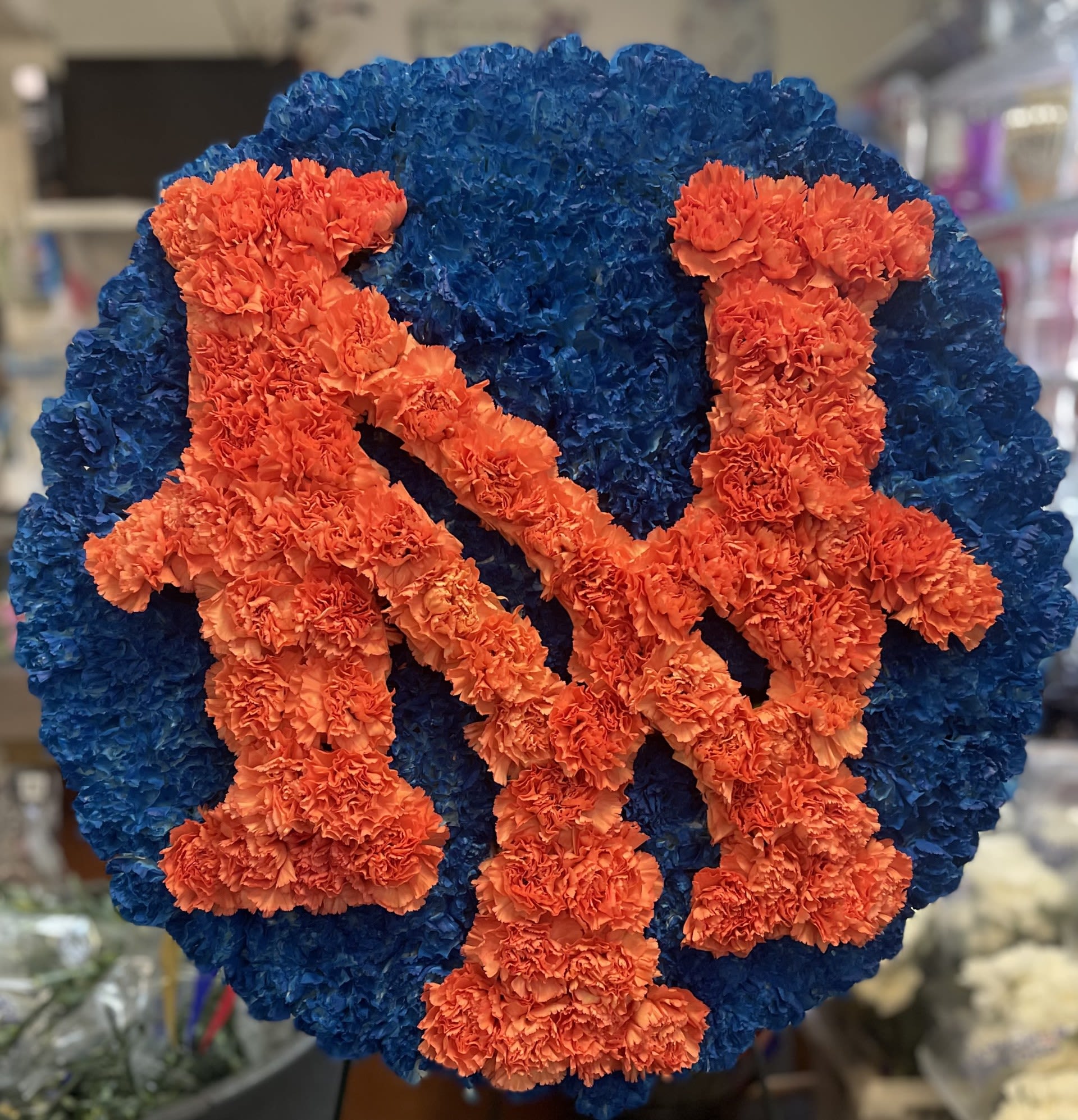 Blue and orange floral tribute with two figures on a round base