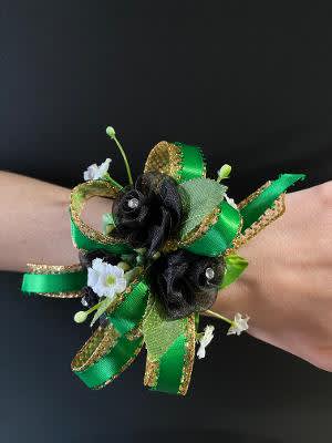 Green ribbon wrist corsage with small black and white flowers