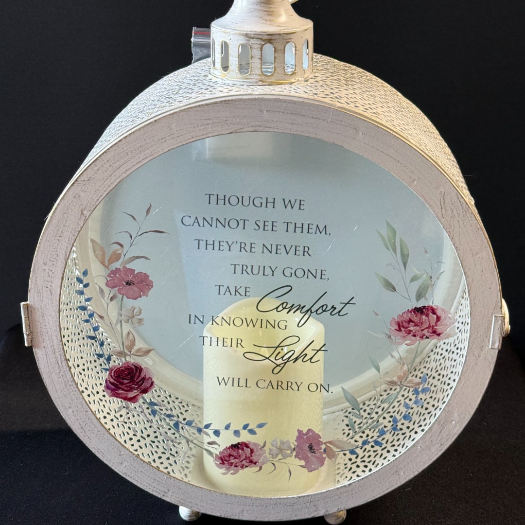 Round memorial lantern with a candle and floral design on the glass