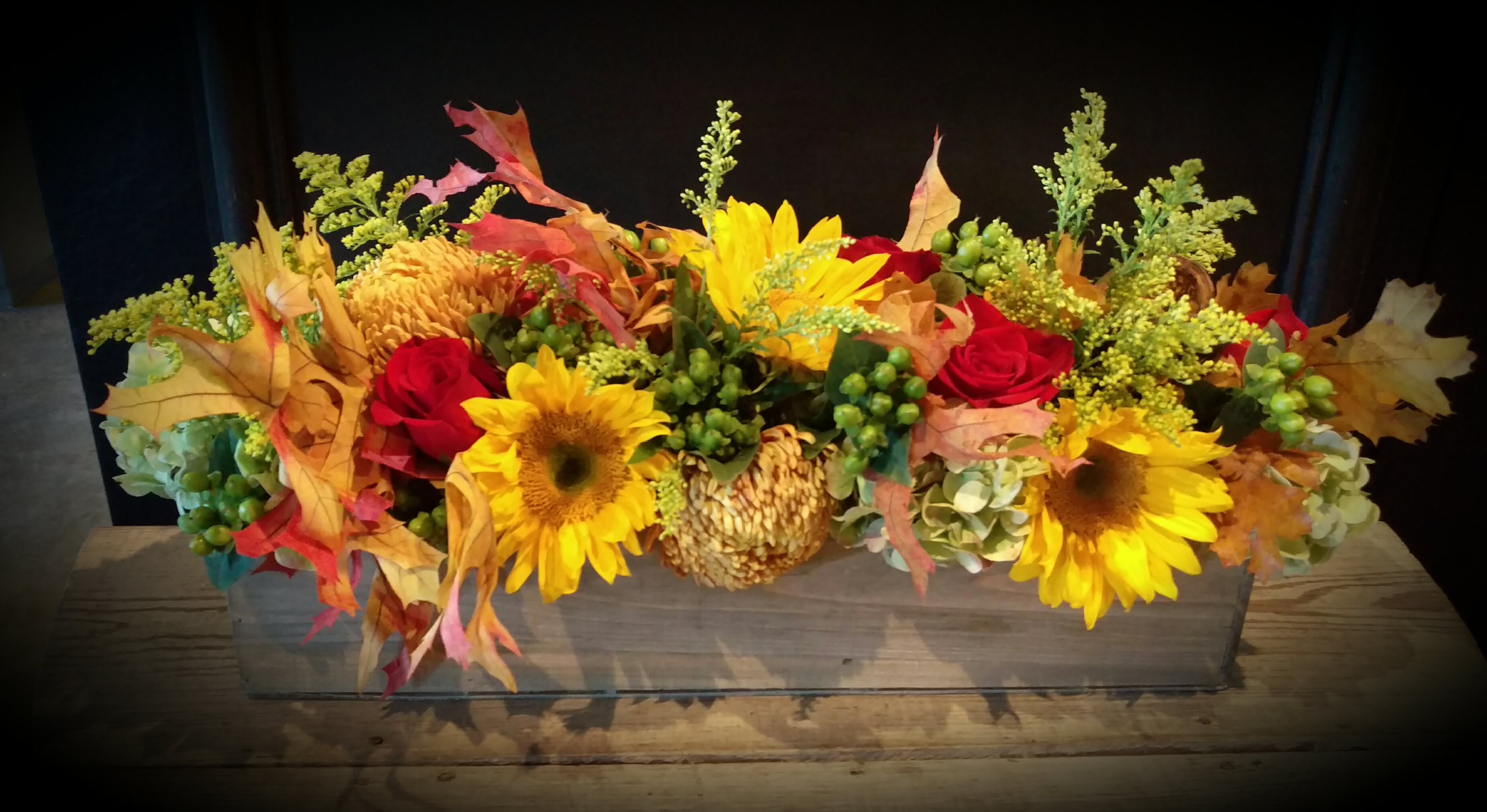 Autumn's Windowbox - Overflowing with the hues of fall and the glory of autumn... this long wooden box features bronze Chinese chrysanthemums, hydrangea,  sunflowers, roses, berries and accents of various wildflowers.  Approx 22" long, 7" wide and 10" tall... perfect for a centerpiece too!