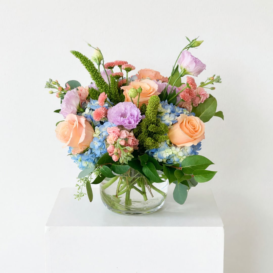 Pastel mixed flower arrangement in a clear glass vase