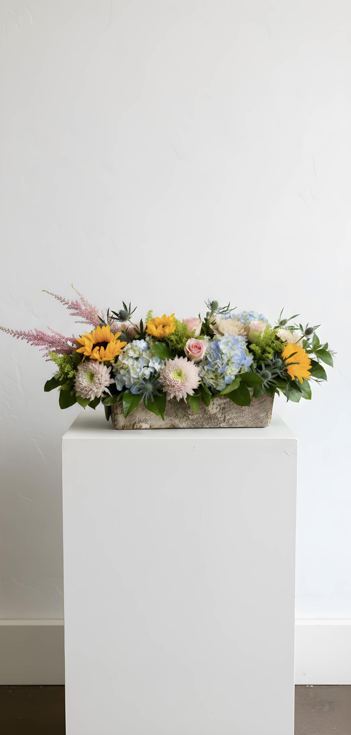 Dewdrop Dawn - A low rectangular container with sunflowers, hydrangeas, and roses- a bright, garden-style arrangement.