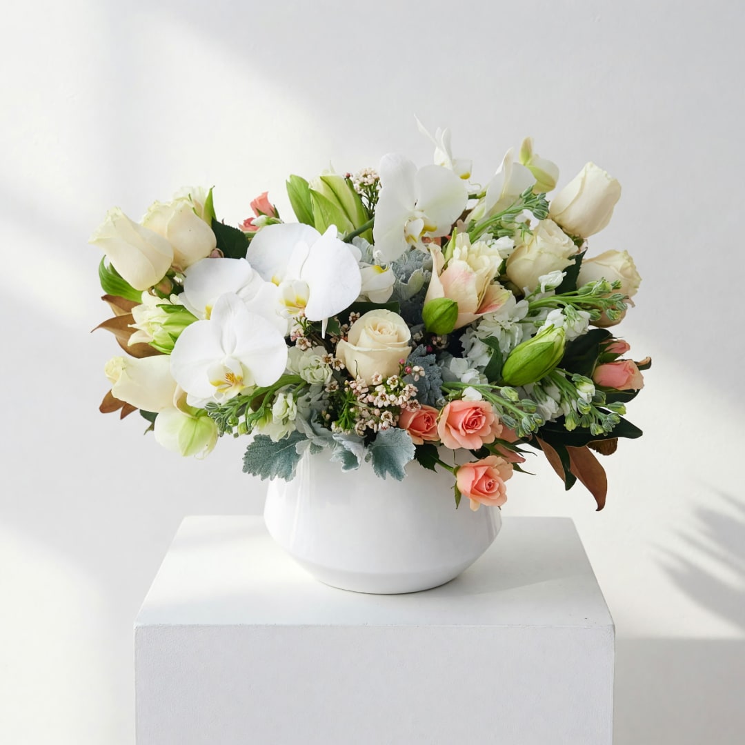 White orchid and rose arrangement in a white vase