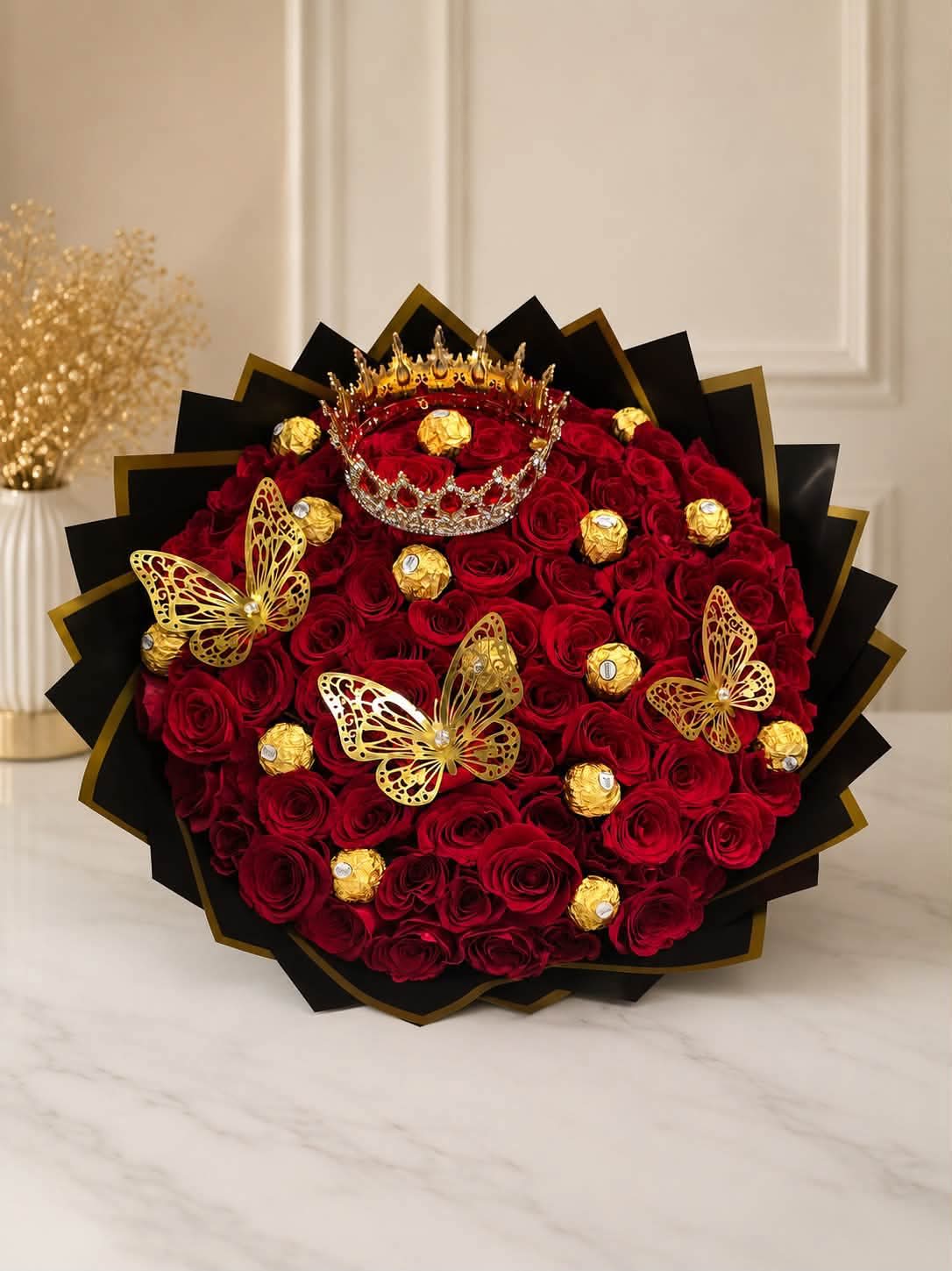Bouquet of red roses with gold butterfly decorations and chocolates