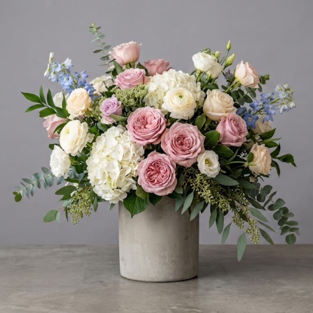 Pink and white roses with hydrangeas in a concrete vase