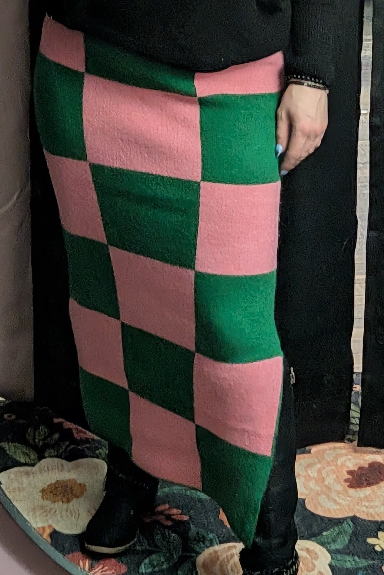 Person wearing a pink and green checkered skirt with a black top