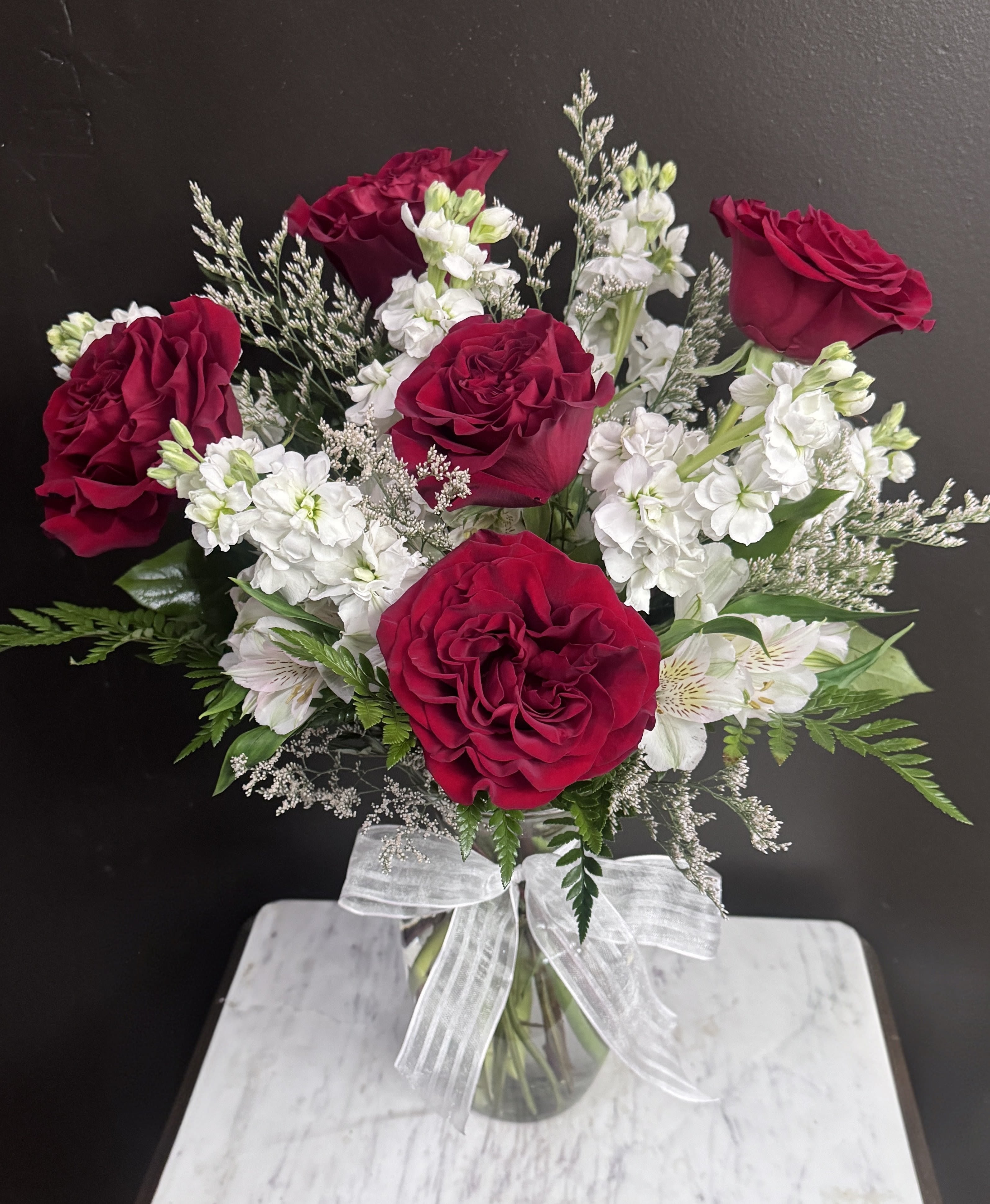 Lover's Lane - Red roses and white stock in a clear glass vase.
