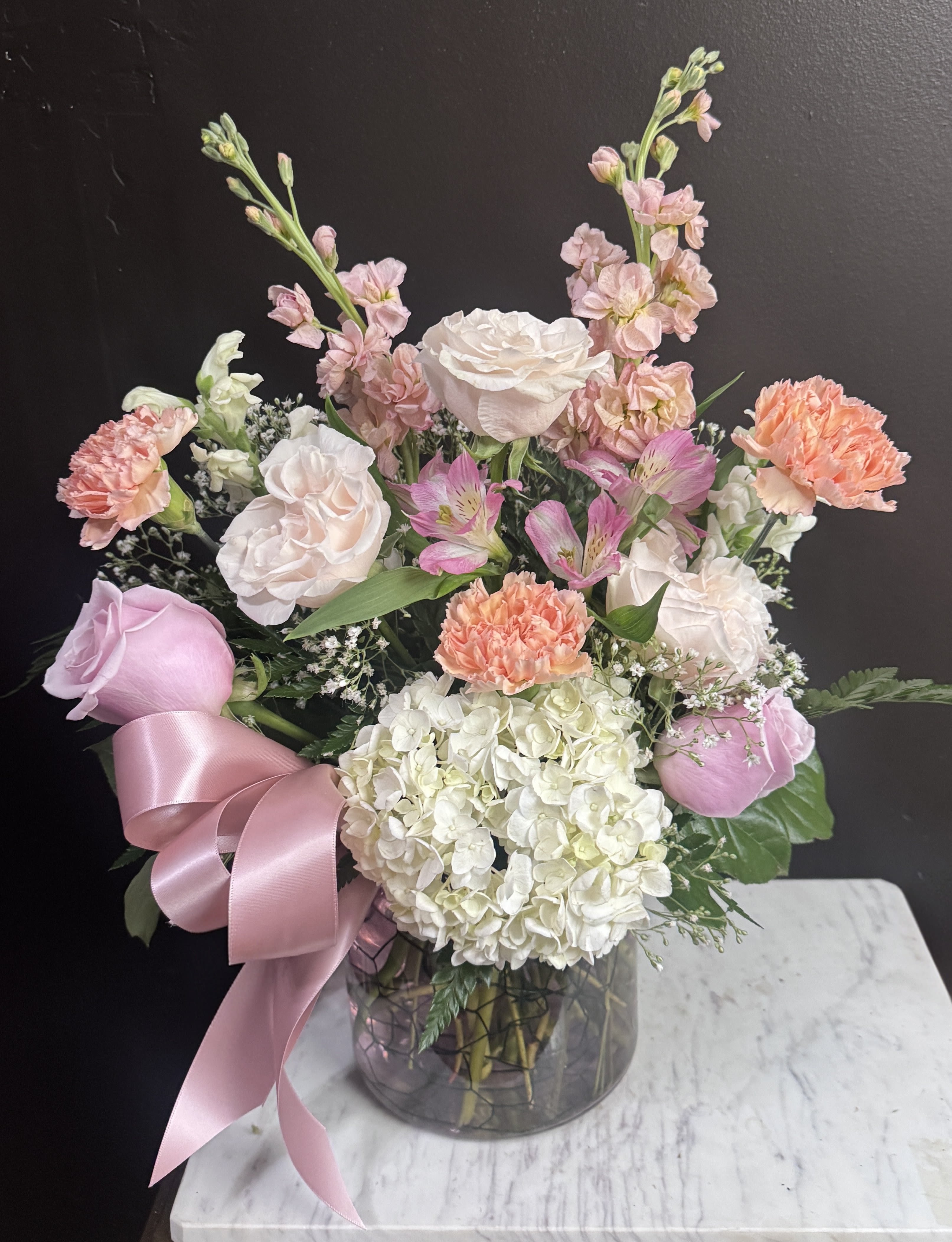 Golden Hour - Pastel pinks and peaches in a clear glass vase.