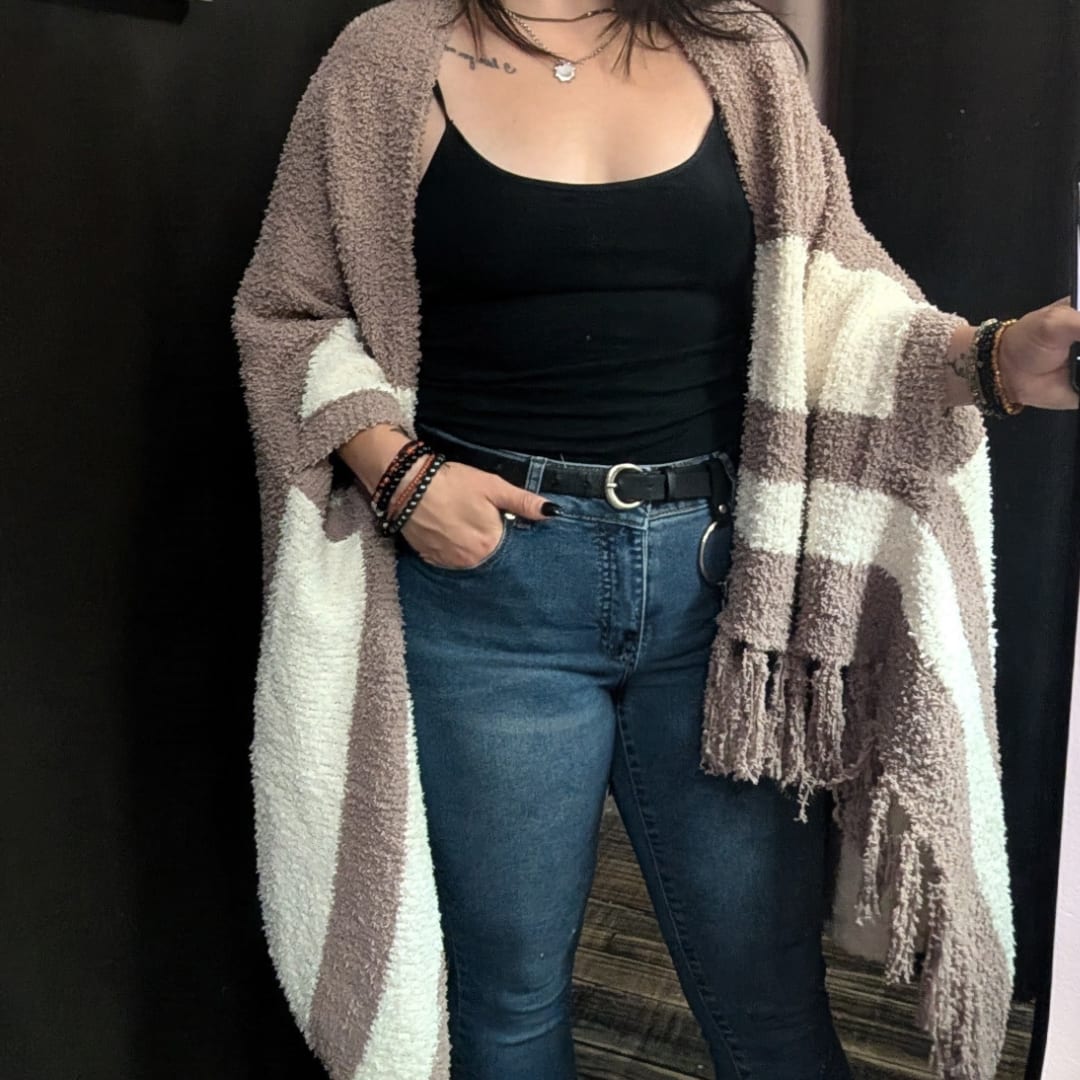 Woman wearing a striped cardigan over a black top and jeans