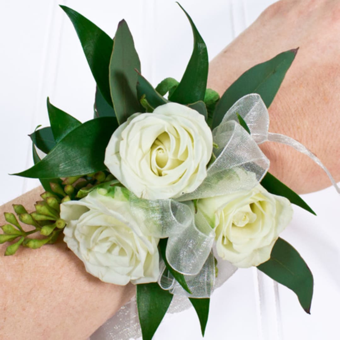 White rose wrist corsage with green leaves and sheer ribbon