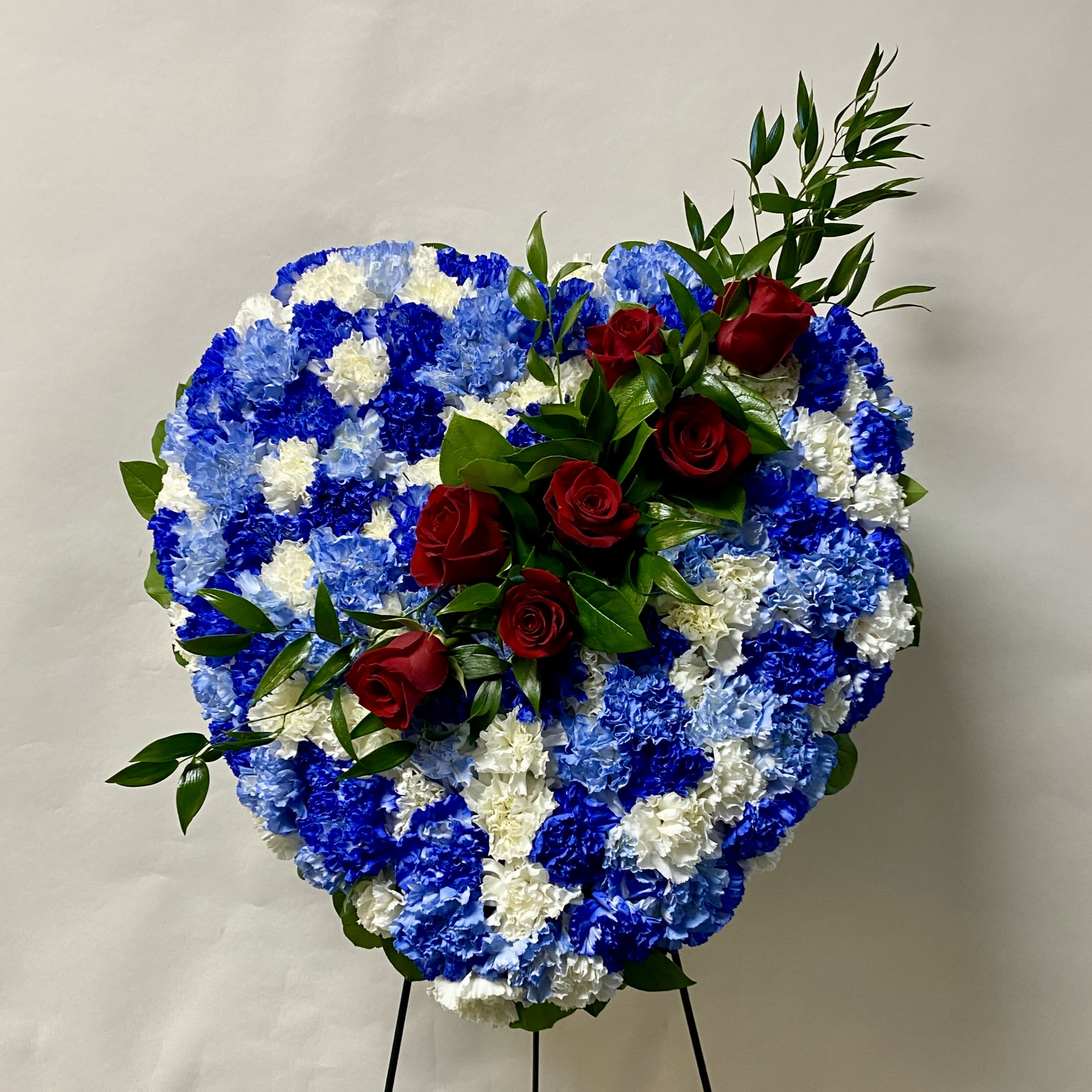 Honor Tribute Solid Heart - This Standing Solid Heart Includes White, Light Blue and Royal Blue Carnations and a Red Rose Sash. Or as Similar as Possible. 