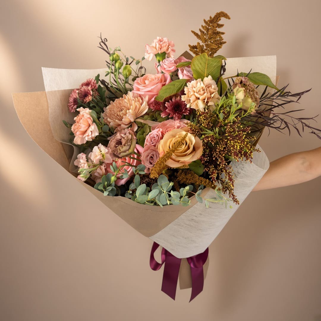 Rose &amp; Gold Bouquet - Seasonal greenery with a selection of rose-colored and deep blush blooms, accented with gold amaranthus and toffee roses. May include lisianthus, antique carnations, peach stock, roses, and a variety of acacia and eucalyptus foliage. 