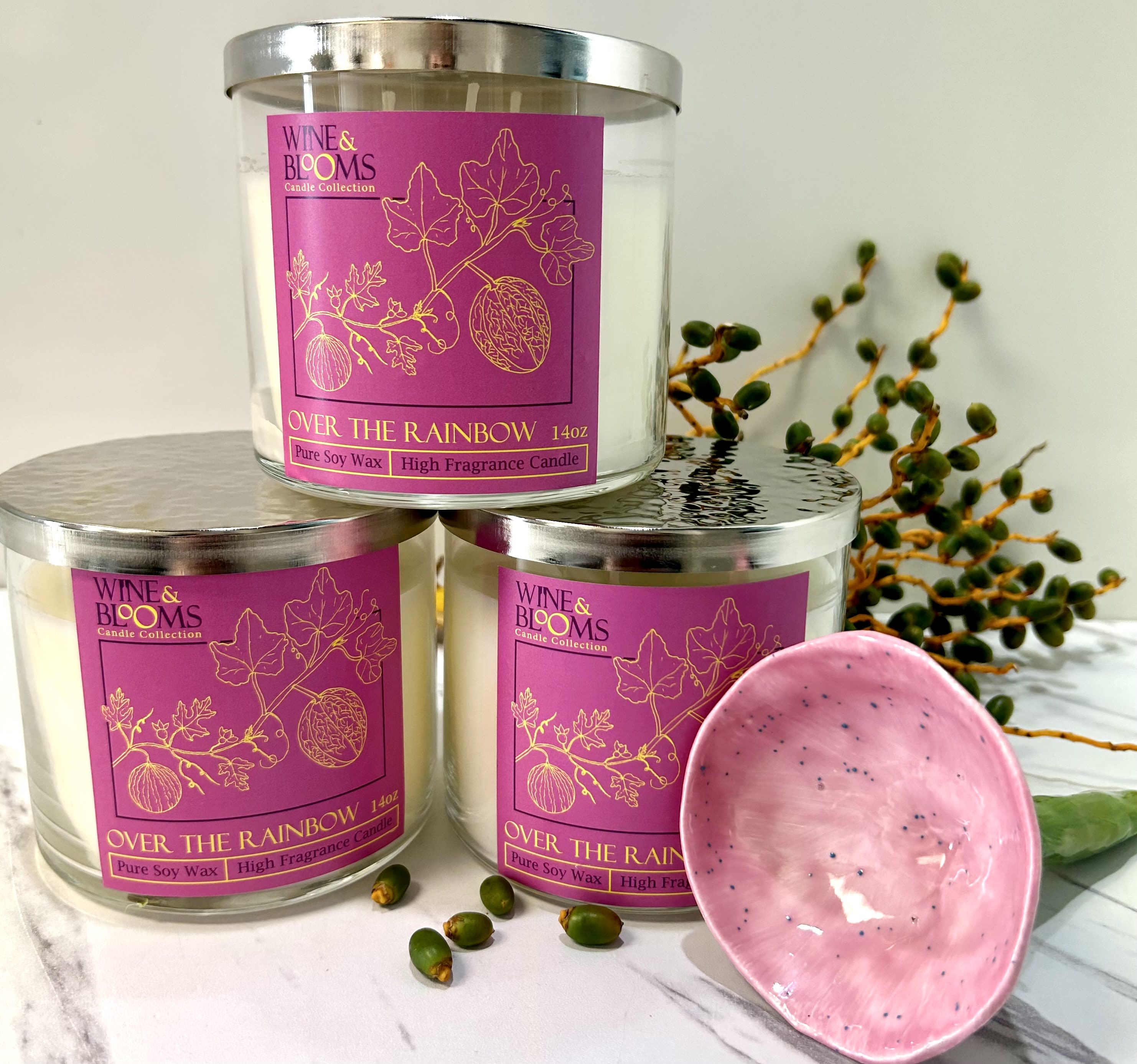Three labeled candles with a pink dish and decorative berries