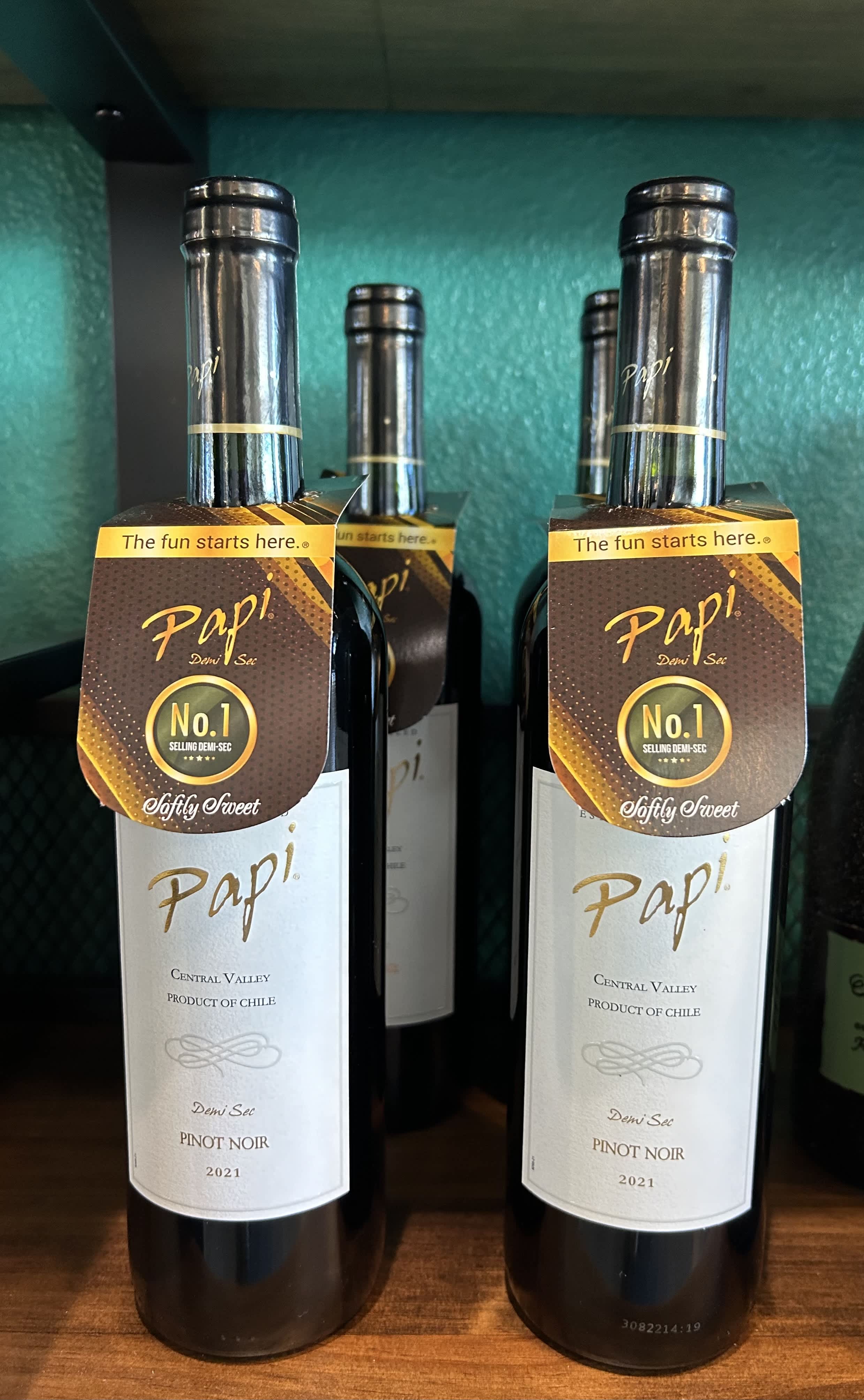 Two bottles of Pinot Noir wine on a shelf
