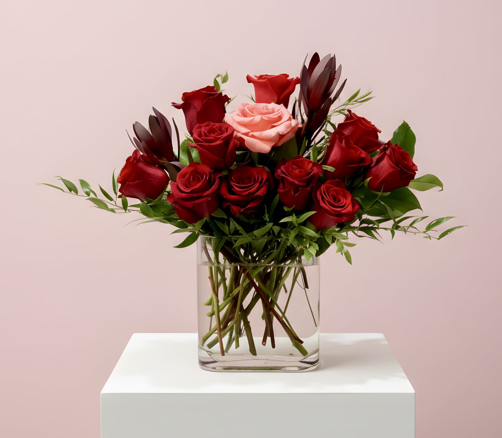 Bouquet of red and pink roses in a clear glass vase