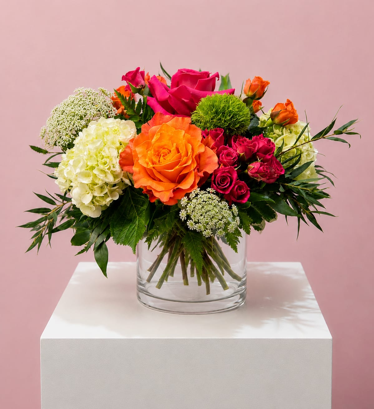 Bright mixed bouquet of roses and hydrangeas in a clear glass vase