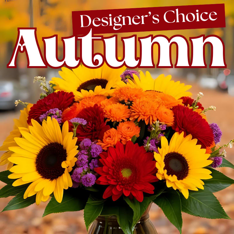 Autumn bouquet with sunflowers, red daisies, and orange blooms in a vase