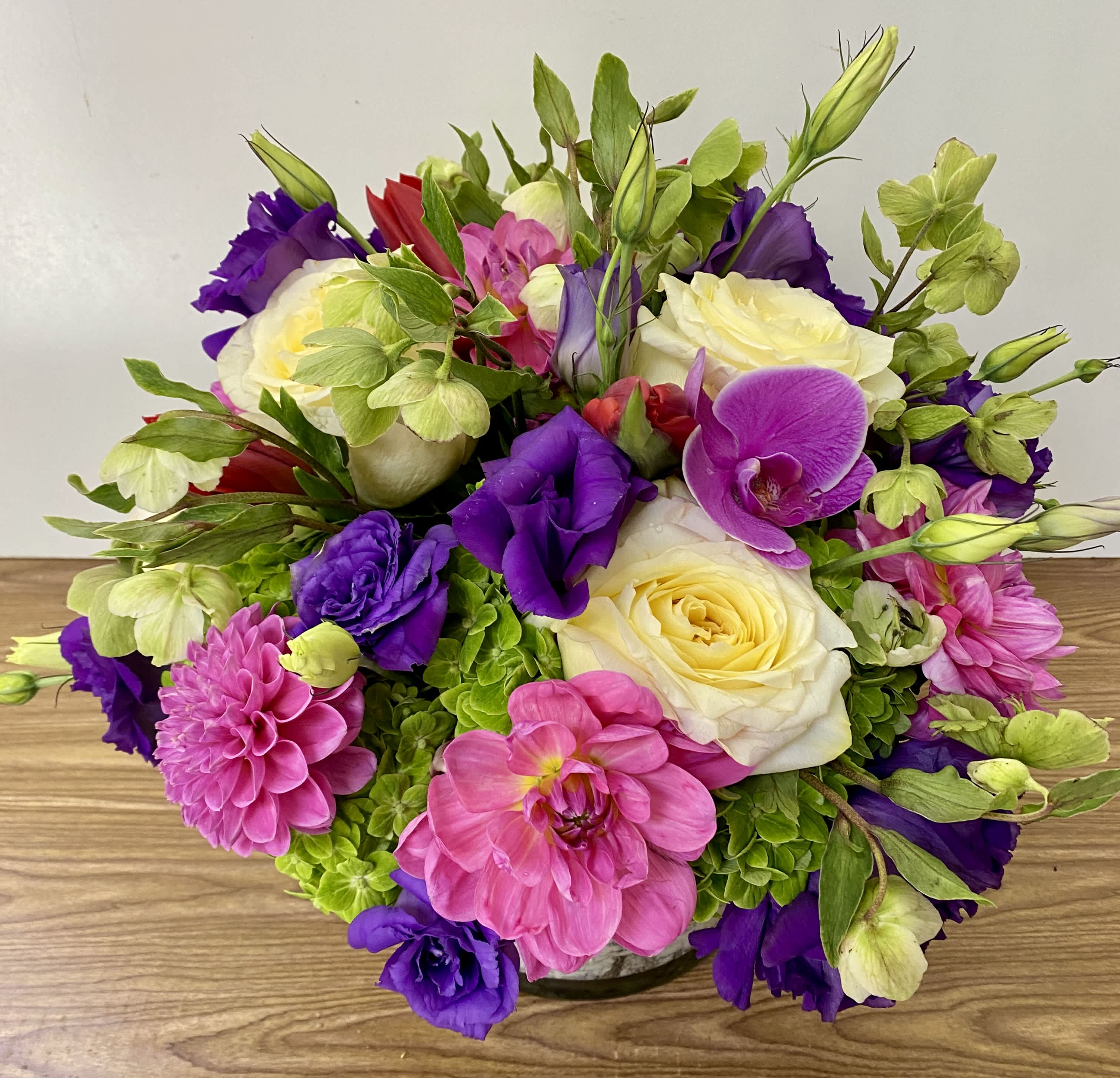 Bouquet of pink, purple, and white flowers in a low vase
