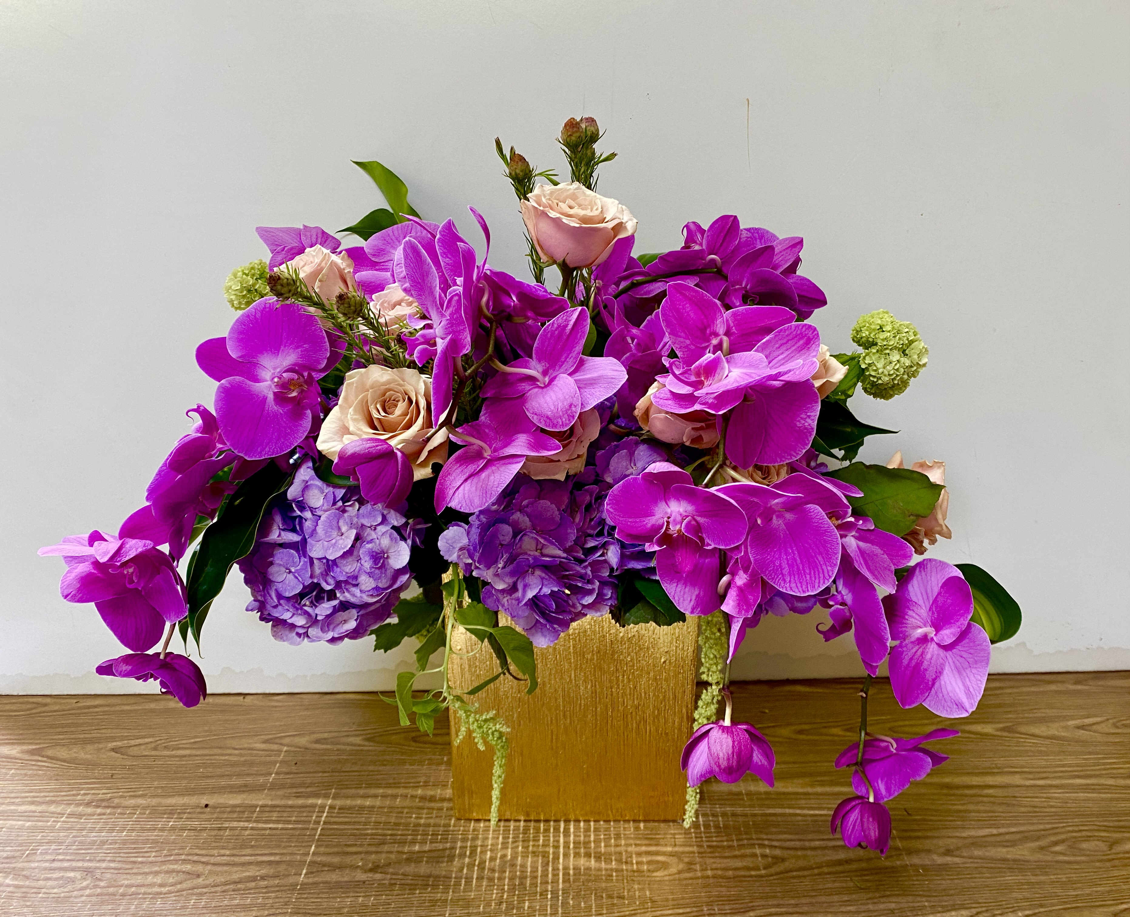 Michael - In a beautiful ceramic pot, combination of purple, hydrogen and purple orchids and green snowballs
