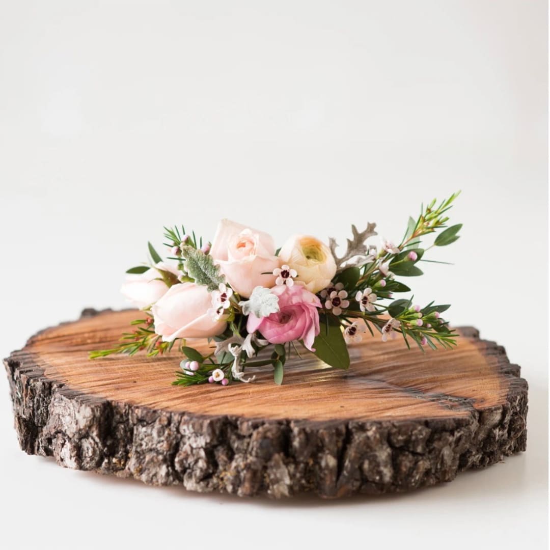 Small pastel floral arrangement on a wood slice
