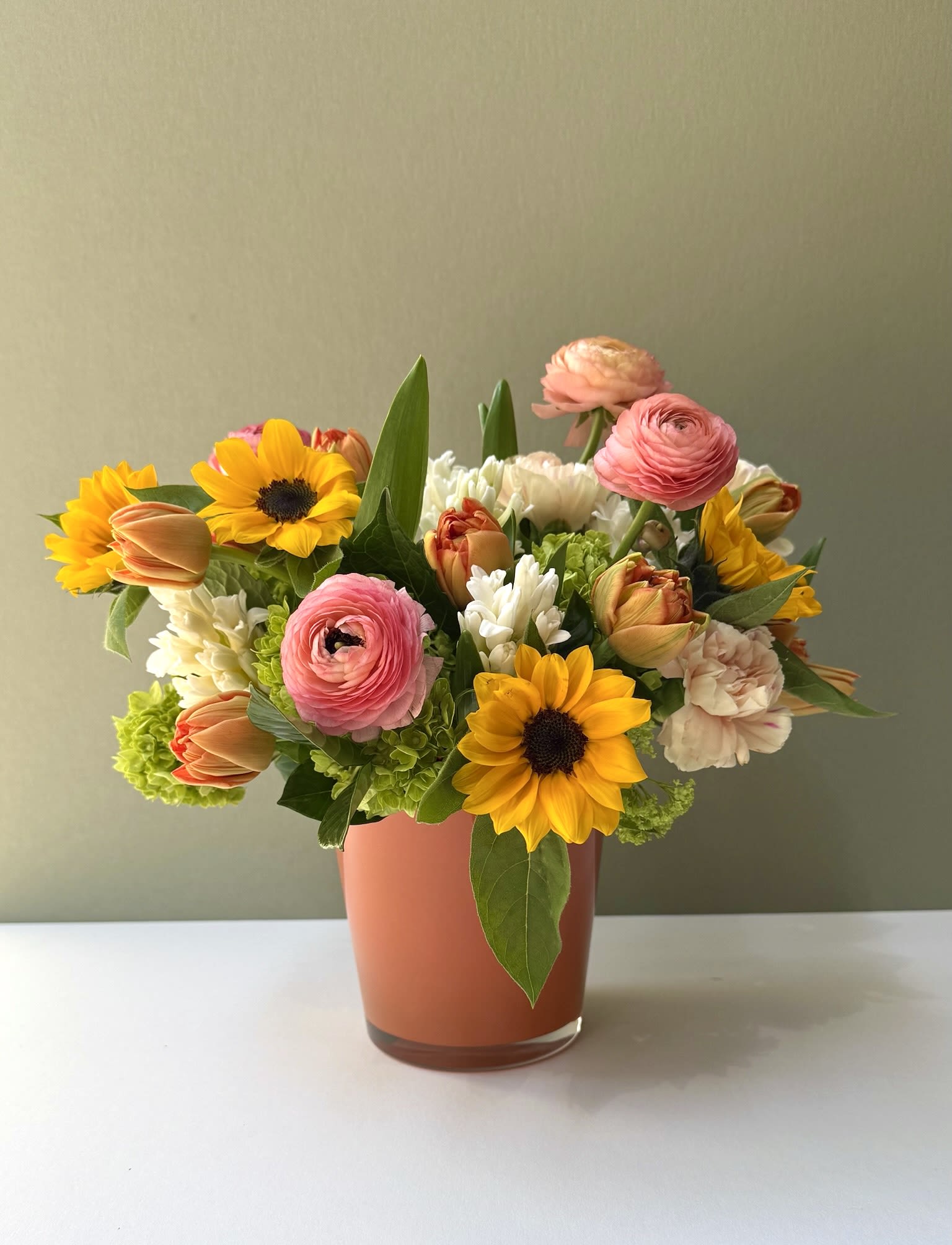 Sunshine - This arrangements smells and looks like a summer sunset with fragrant hyacinths, ranunculus, sunflowers and hydrangeas.