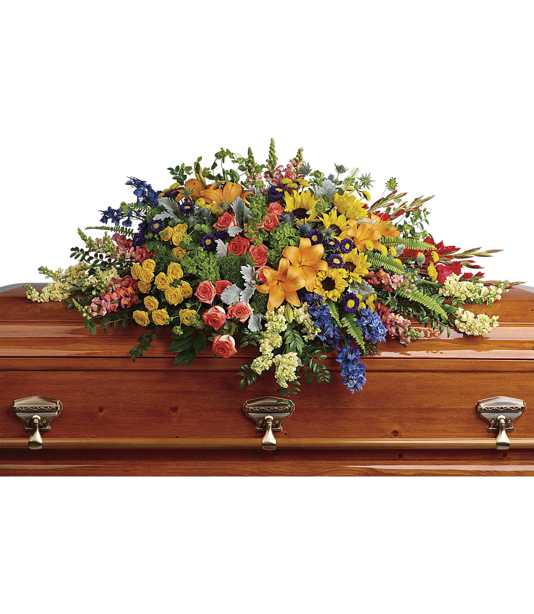 Colorful casket spray of mixed flowers including lilies, roses, and sunflowers on a wooden casket.