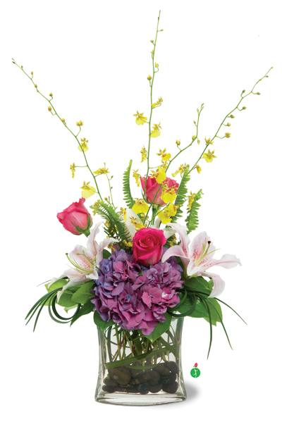 Pink roses and lilies in a glass vase with purple hydrangea