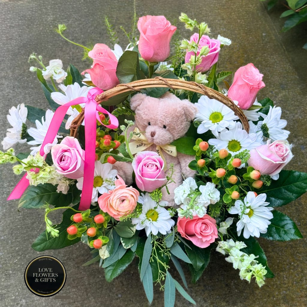 Pink rose basket with a teddy bear and white daisies