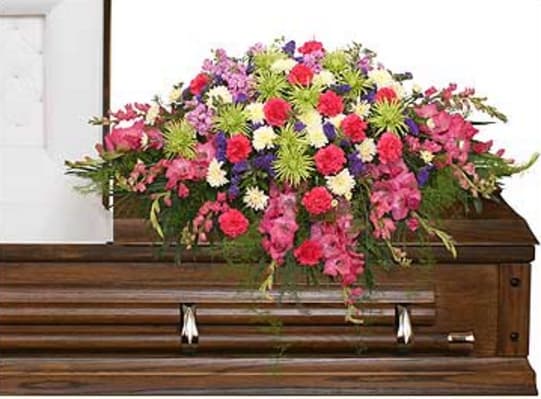 Colorful floral spray on a wooden casket