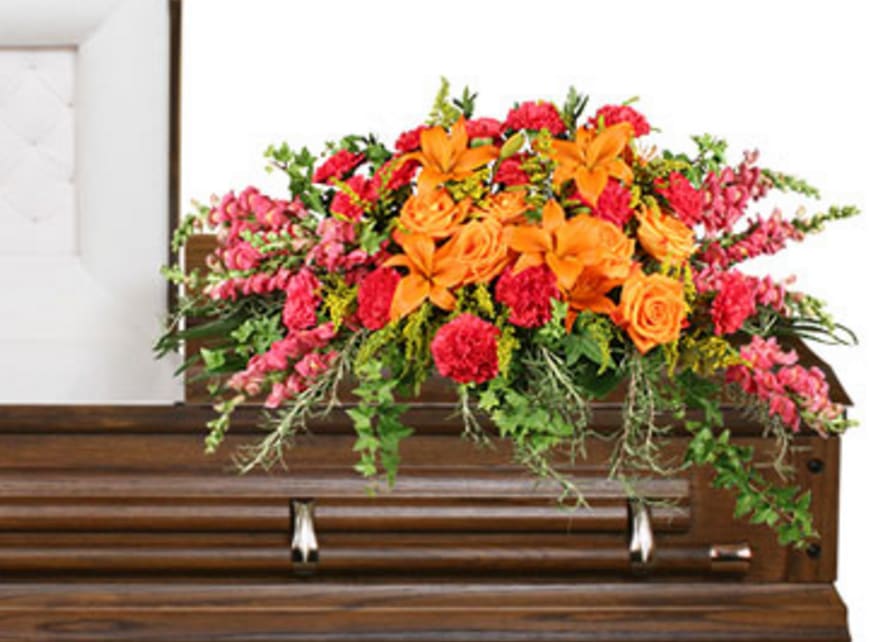 Bright floral arrangement on a wooden casket