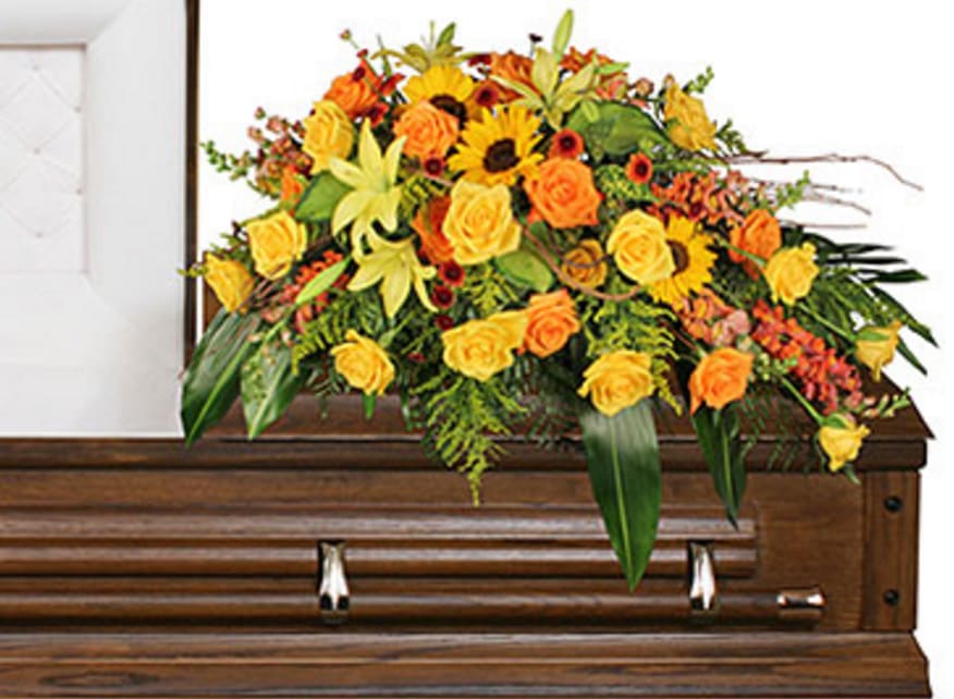 Yellow and orange floral spray on a wooden casket