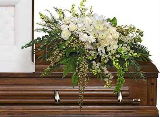 White floral spray on a wooden casket