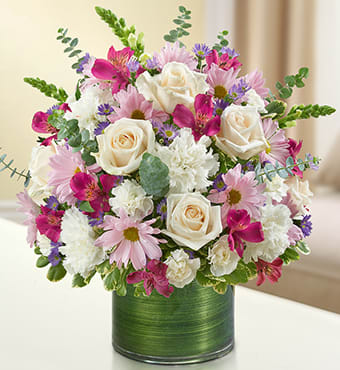 Pink and white mixed flower arrangement in a green vase