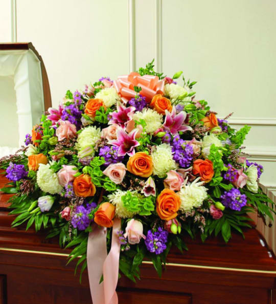 Large casket spray with orange, pink, purple, and white flowers