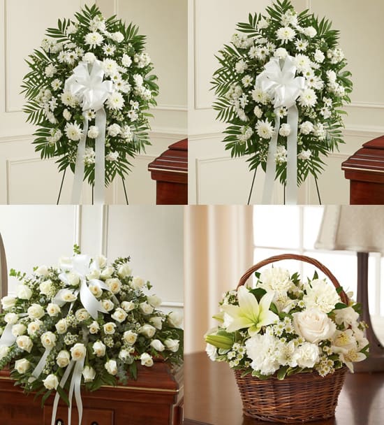 White funeral floral arrangements with ribbons and a basket centerpiece