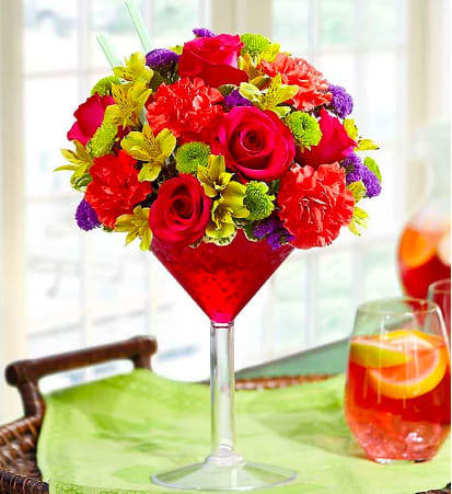Bright mixed bouquet in a tall red martini glass vase