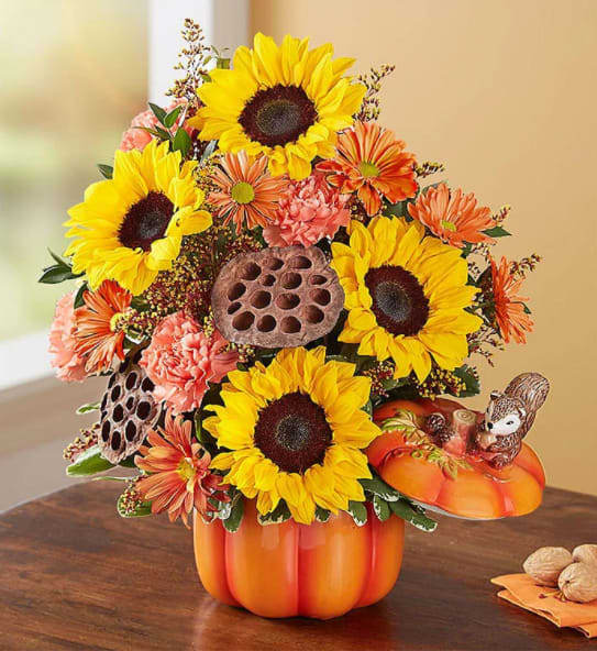 Pumpkin N' Posies - Our truly original pumpkin arrangement captures all the wonder of the season. Golden and orange blooms blended with rustic, natural accents, it’s designed in our ceramic pumpkin container that features a whimsical woodland squirrel perched atop the matching lid. Whether used for holding trinkets or as part of the décor, this artisan-style canister will add warmth and charm to their home year after year.