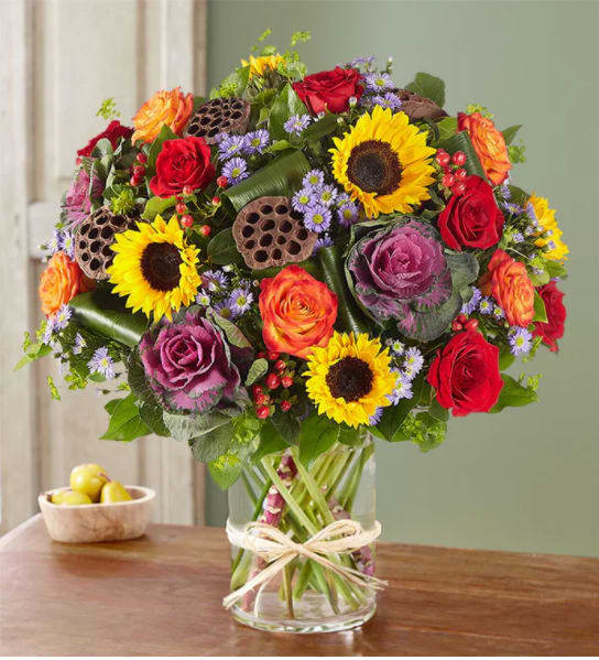Mixed bouquet of roses and sunflowers in a glass vase