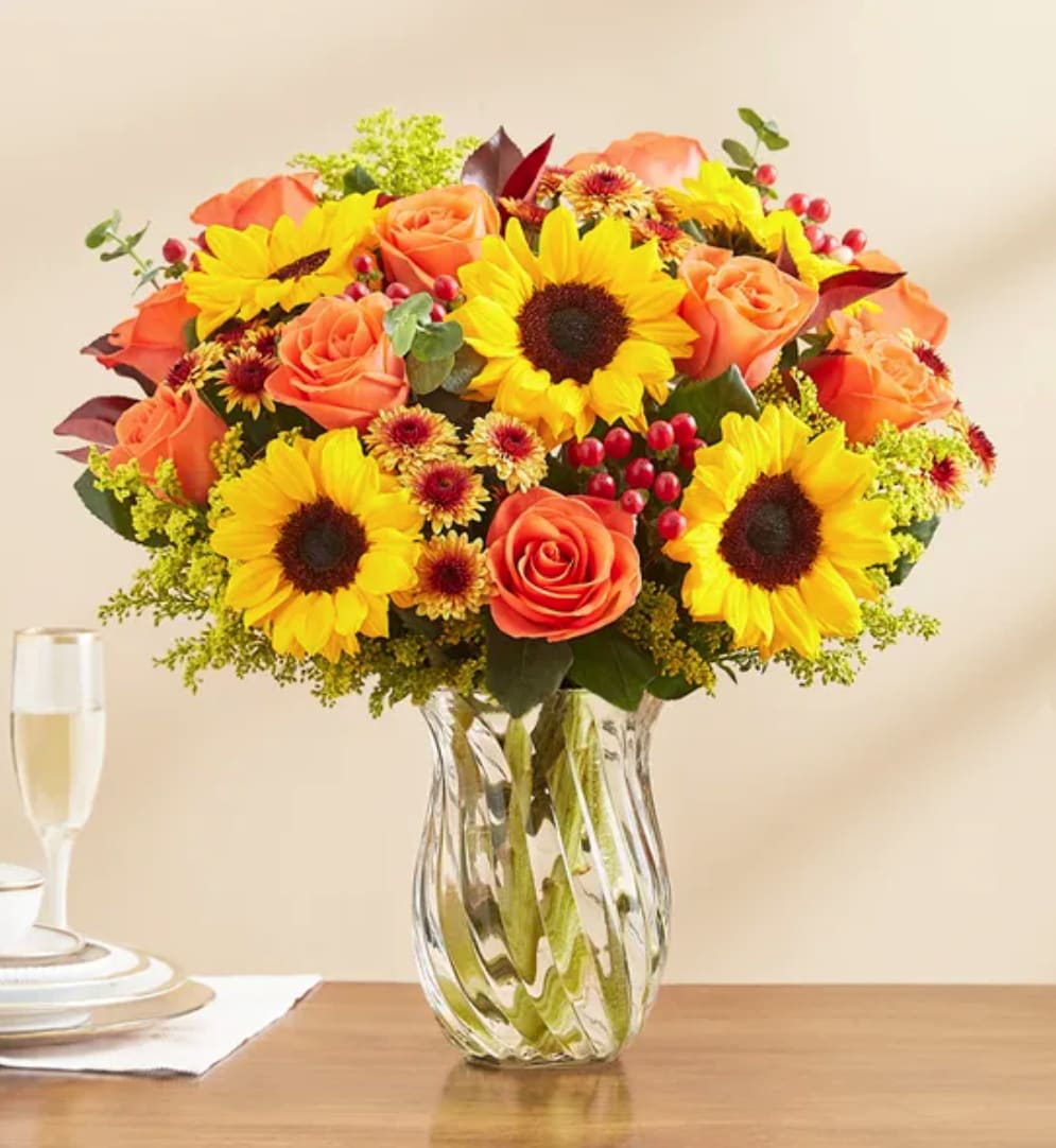Fall Spectacular Bouquet - We’re putting fall on spectacular display! Our farm-fresh gathering is filled with fiery orange roses, signature golden sunflowers and warm bronze button poms. Together with rich greenery and textured berry accents, it’s a gift that brings the beauty of the season to life.